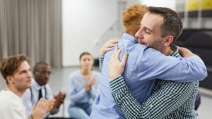 An individual comforting a peer during group therapy as part of Suboxone treatment.