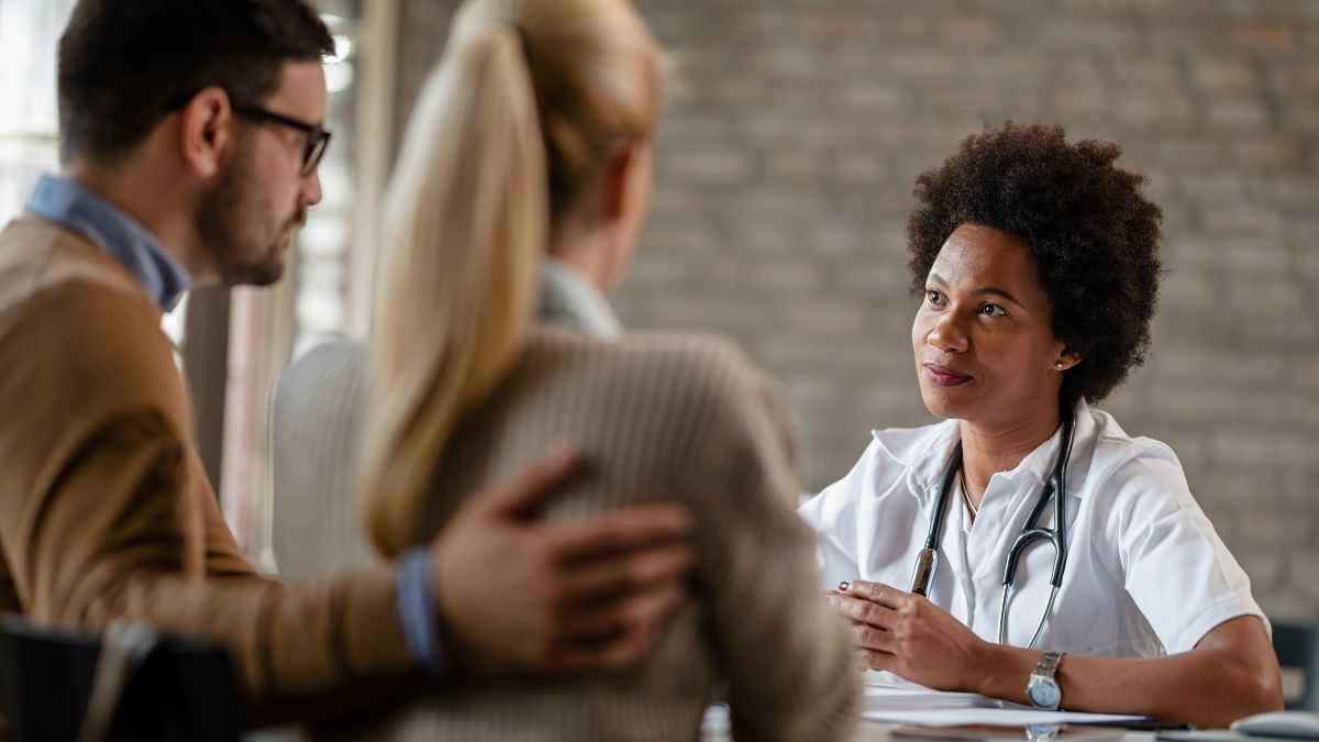 A couple consulting a professional regarding the types of medication-assisted treatment.